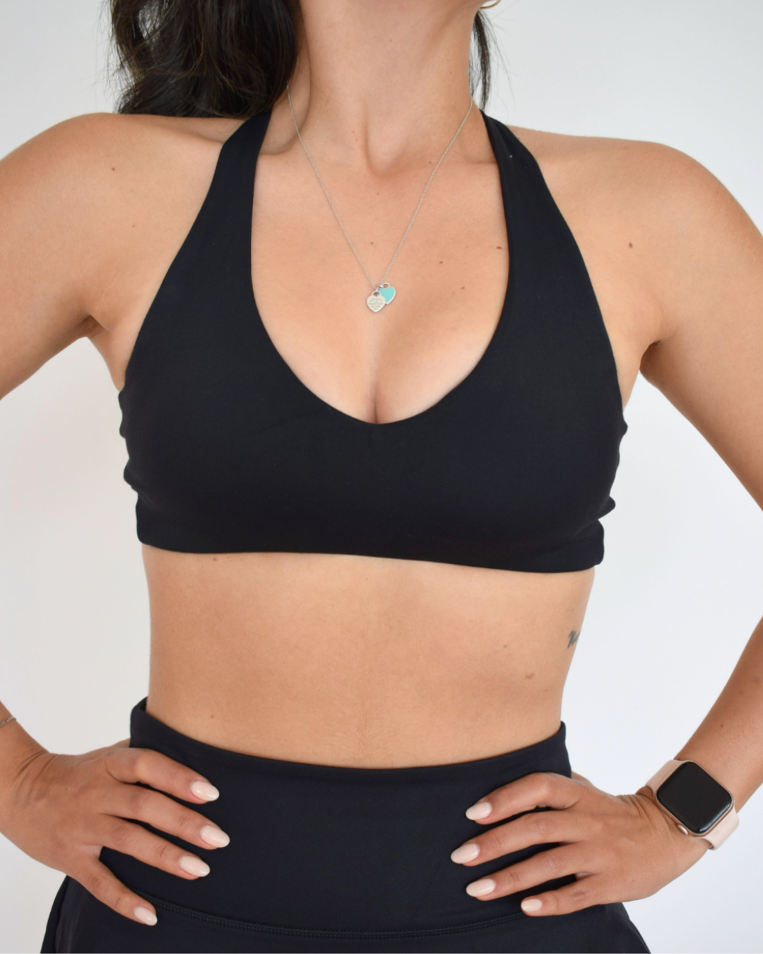 Detalle frontal del Core Loop Bra negro de Muv&Glow, escote en V con costuras suaves y fit cómodo.