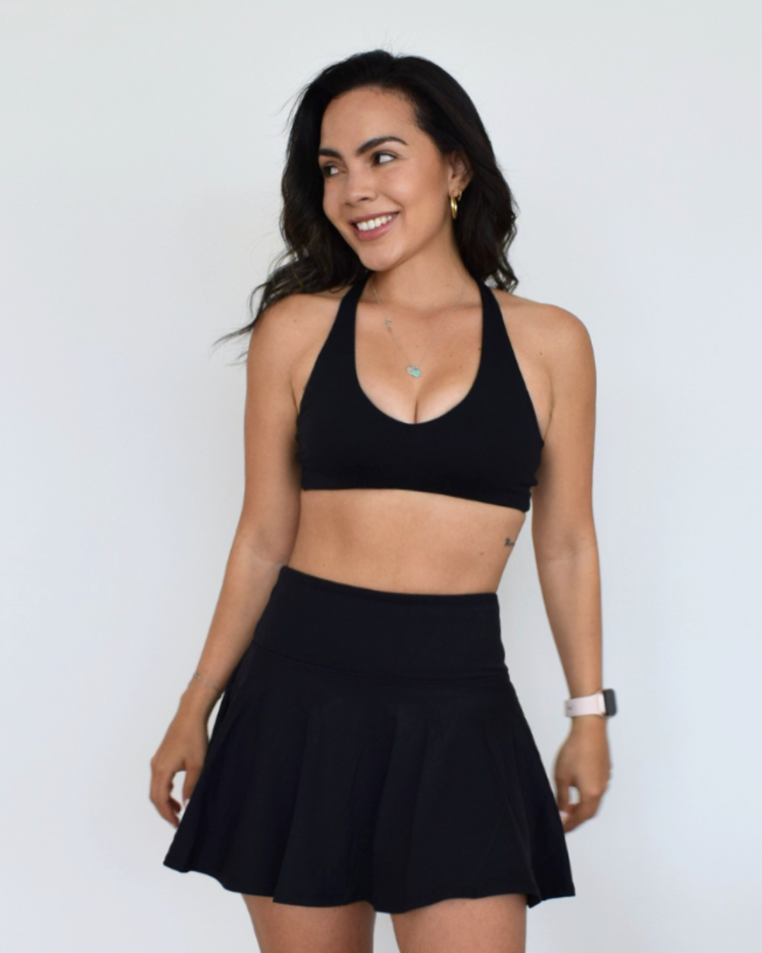Modelo usando el Core Loop Bra negro de Muv&Glow, top deportivo minimalista de soporte ligero.