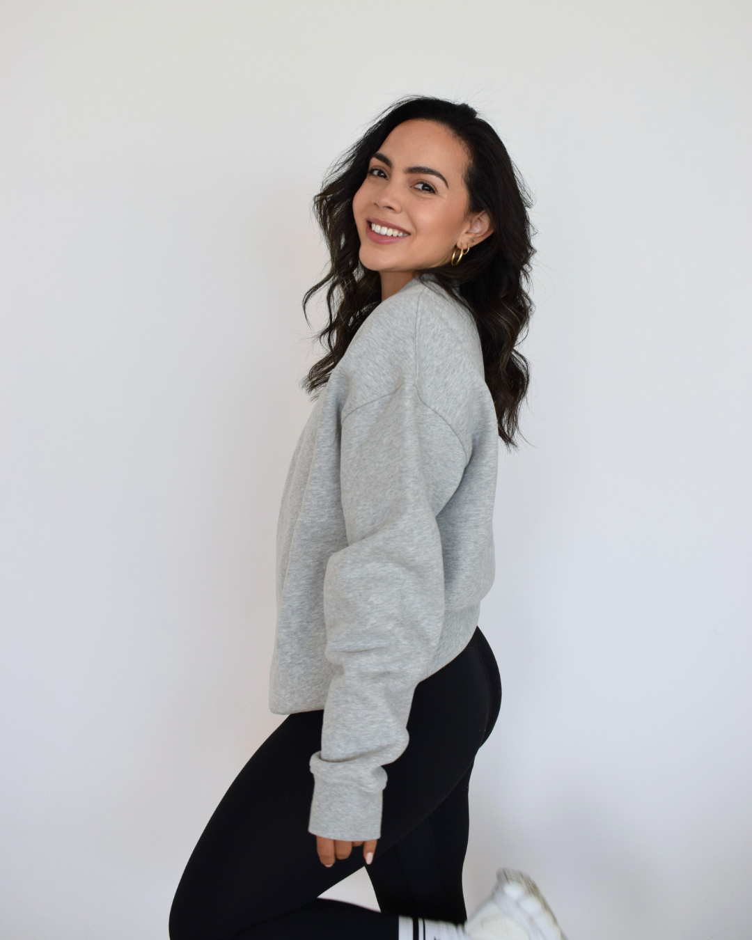 Vista lateral del Essential Pullover gris de Muv&Glow, polerón oversize y cómodo para uso diario.