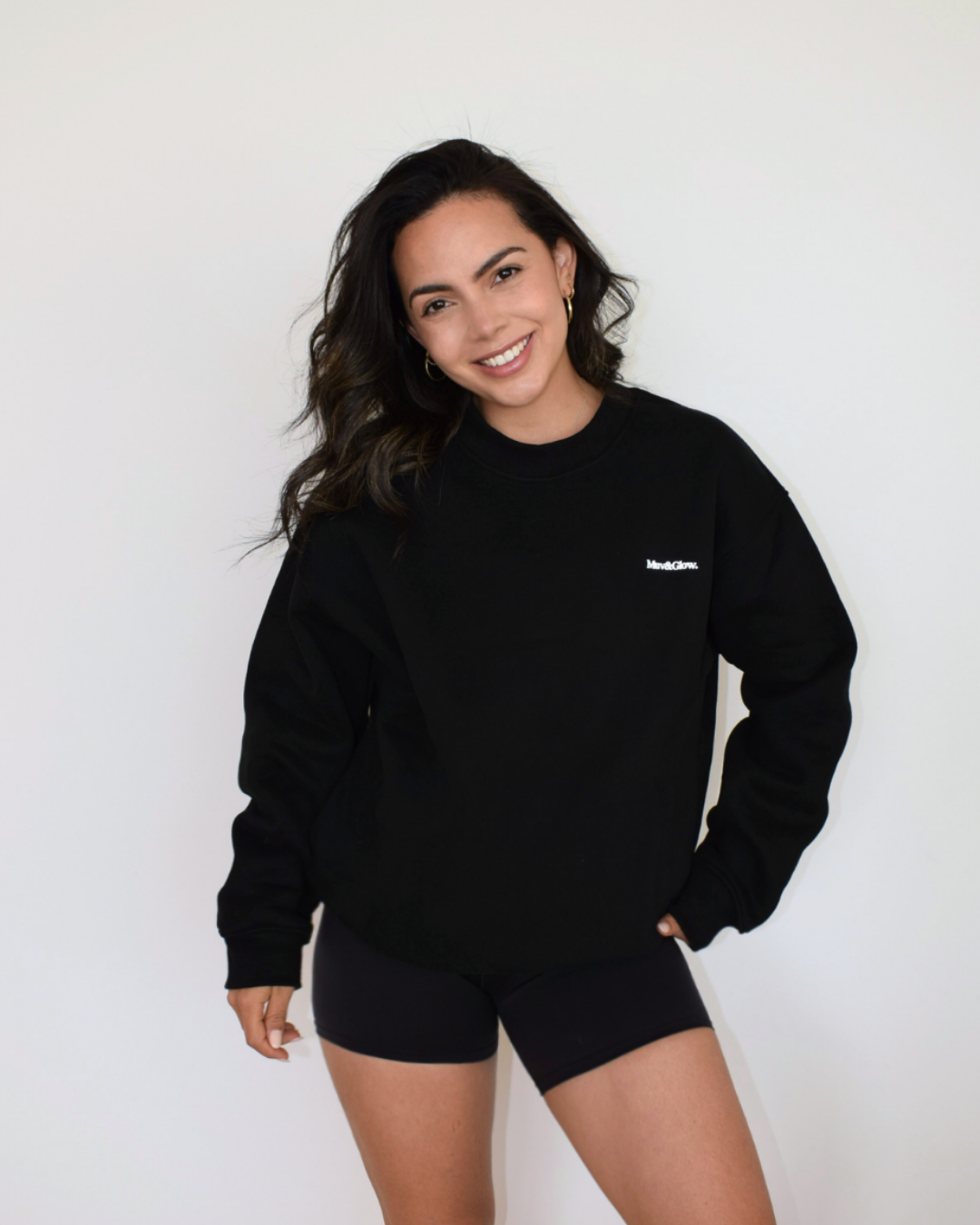 Modelo luciendo el Essential Pullover negro de Muv&Glow, look casual con estilo minimalista.
