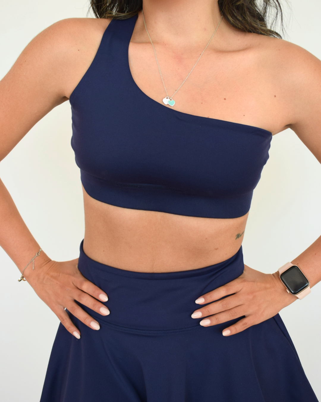 Primer plano frontal del top asimétrico azul marino The Core