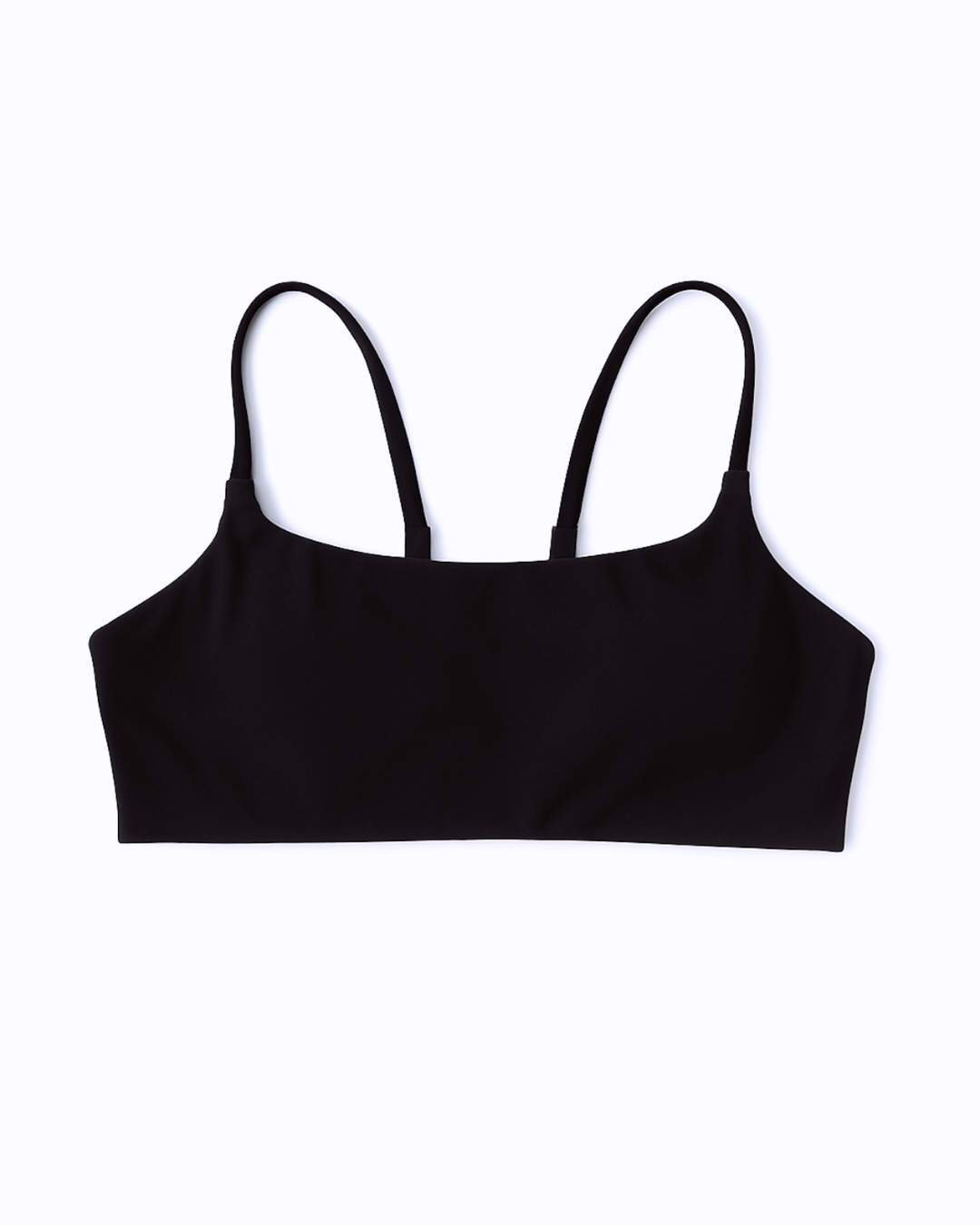 Flat lay del Core Bra negro de Muv&Glow sobre fondo blanco, top deportivo ideal para yoga o pilates.

