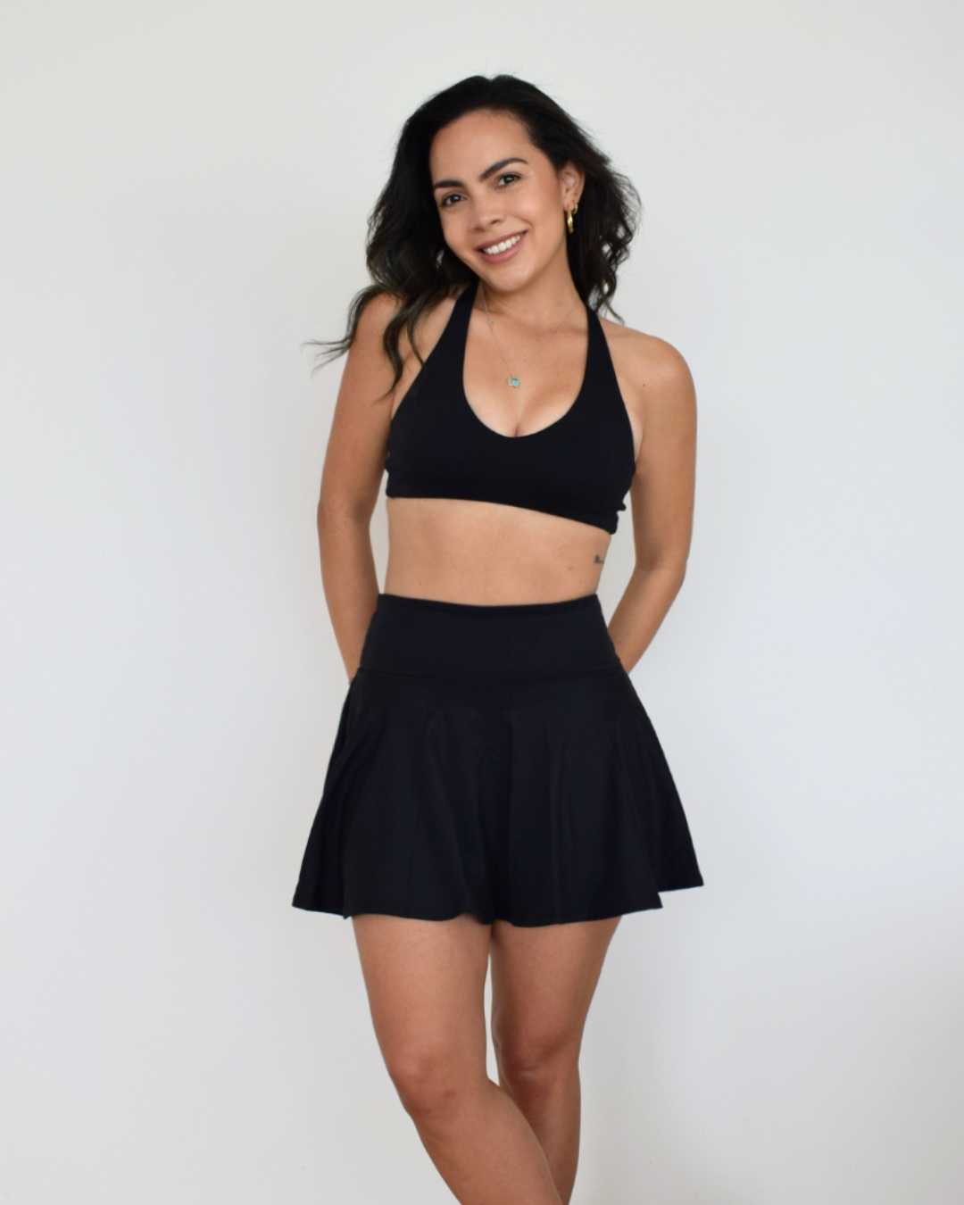 Modelo luciendo el Core Loop Bra negro de Muv&Glow, diseño limpio ideal para yoga o uso diario.
