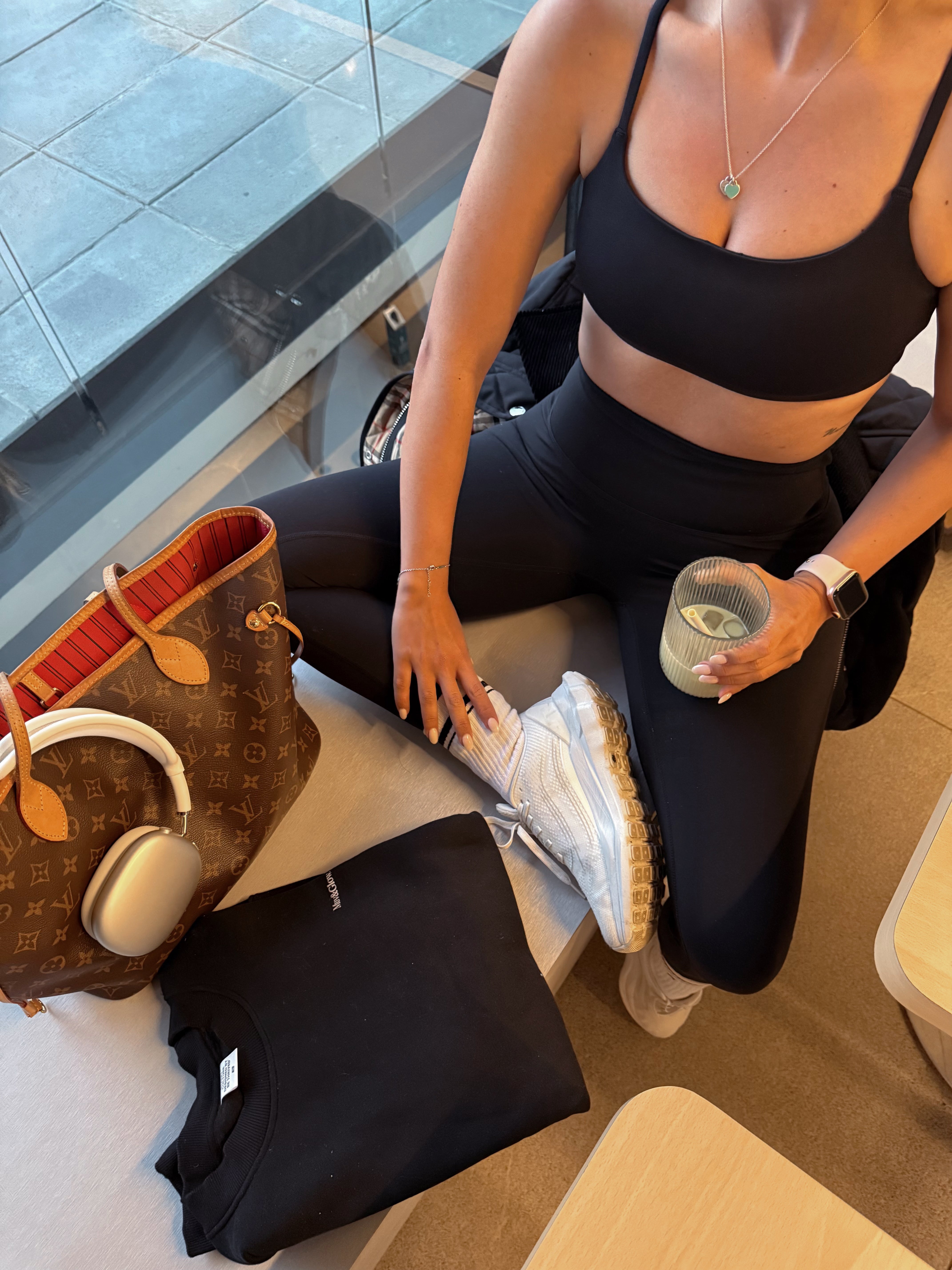 Modelo con conjunto Core Bra y Core Leggings negros de Muv&Glow tomando matcha