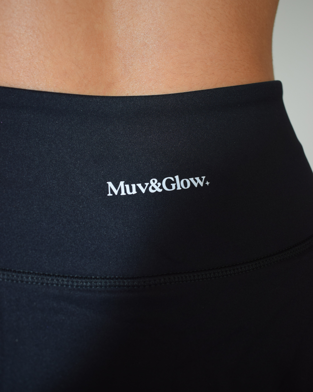 Detalle del logo bordado en The Core Skirt negro de Muv&Glow, pretina ancha de alta sujeción.
