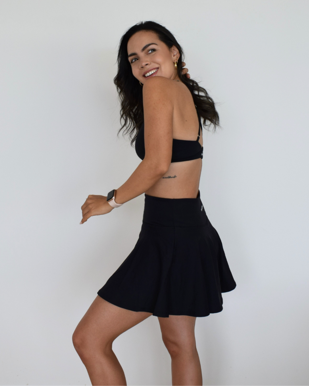 Vista lateral de The Core Skirt negro de Muv&Glow, falda con vuelo ideal para tenis, pádel o entrenamiento.
