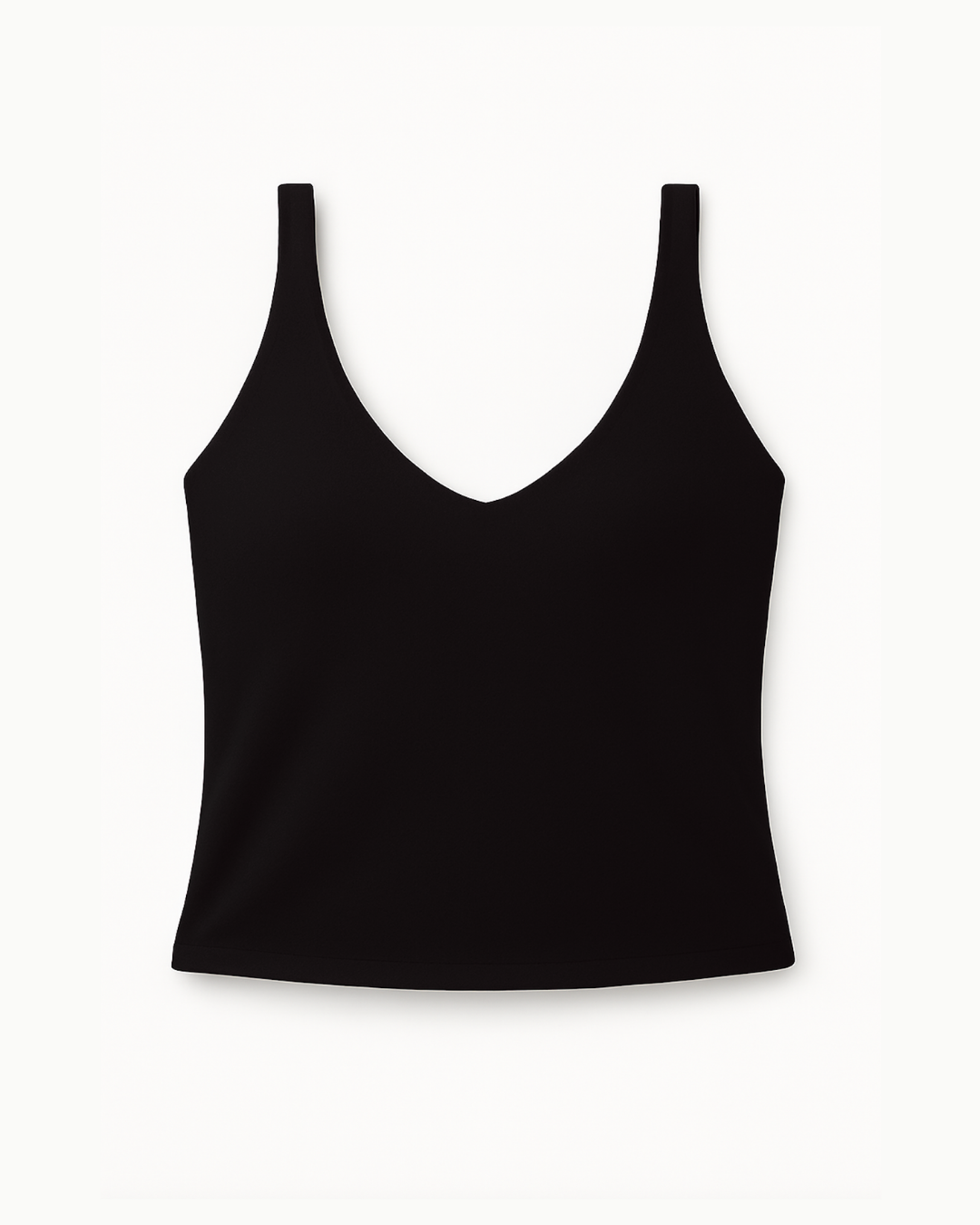 Flat lay del Core Twist Top negro de Muv&Glow sobre fondo blanco, top largo con tirantes cruzados.
