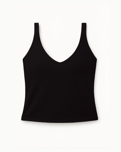 Flat lay del Core Twist Top negro de Muv&Glow sobre fondo blanco, top largo con tirantes cruzados.
