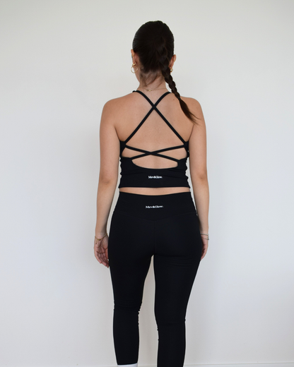 Vista trasera del Core Twist Top negro de Muv&Glow con tirantes cruzados y espalda descubierta.
