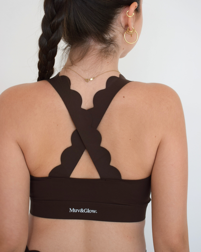Vista trasera del The Edge Bra en espresso de Muv&Glow, top deportivo con tirantes anchos cruzados.
