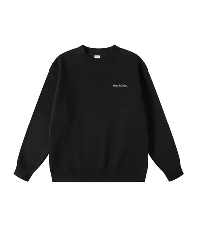 Flat lay del Essential Pullover negro de Muv&Glow sobre fondo blanco, sudadera básica con corte oversize.
