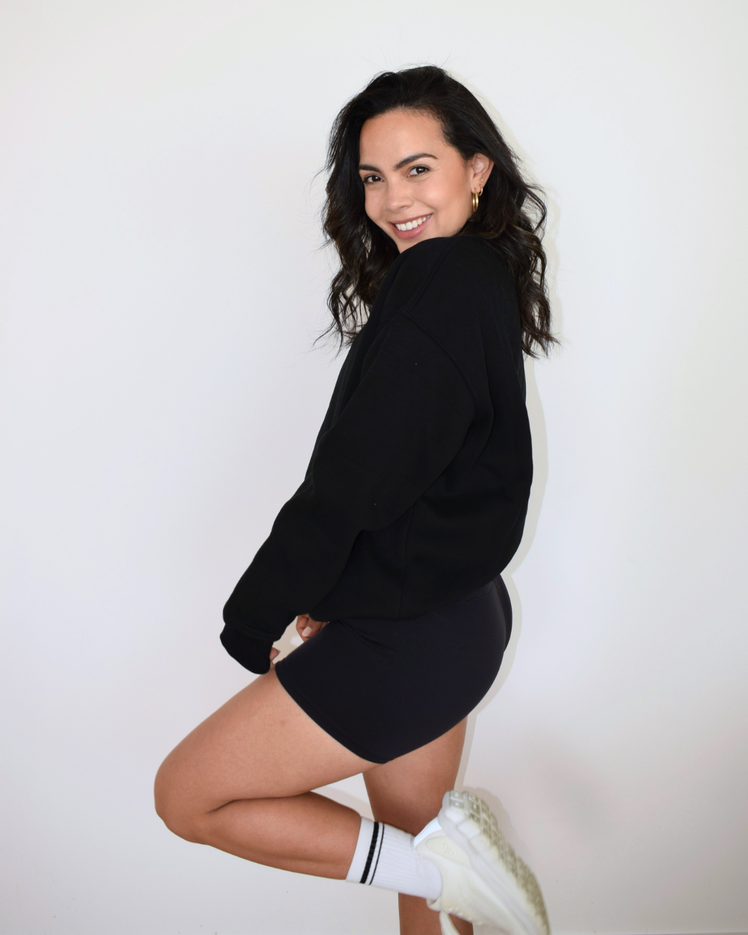 Modelo con el Essential Pullover negro de Muv&Glow, polerón cómodo para uso diario o post-entreno.