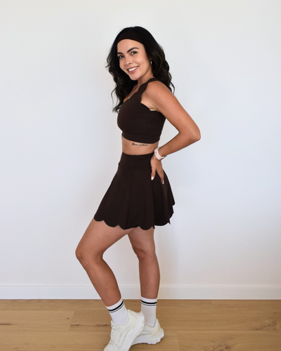 Modelo usando el bra The Edge de Muv&Glow con falda a juego color espresso