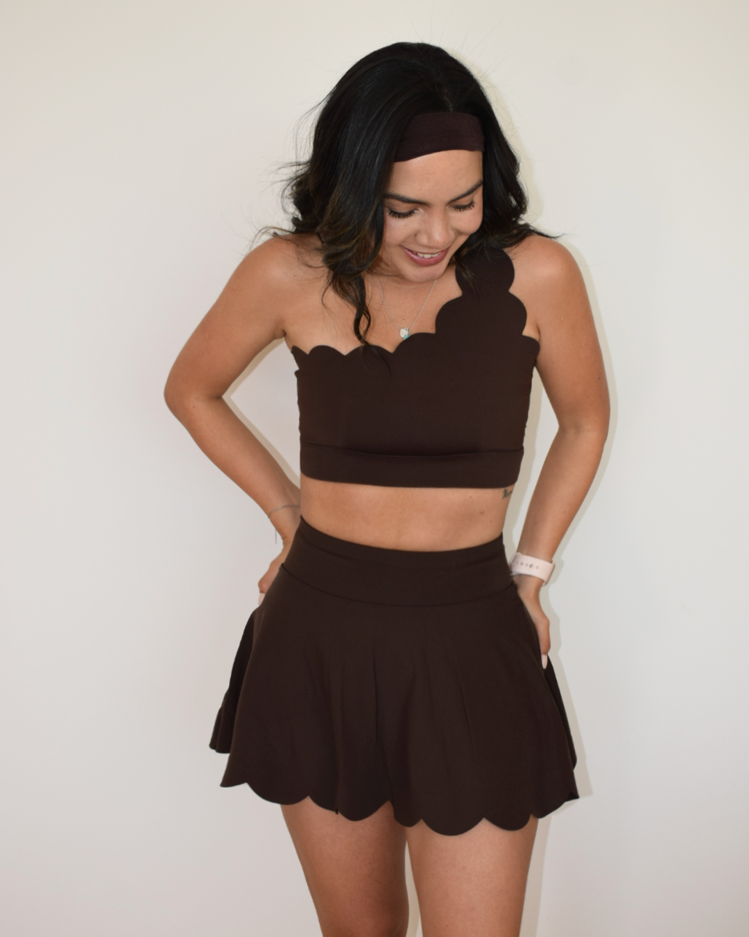 Modelo usando la falda The Edge de Muv&Glow, manos en la cintura
