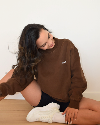 Modelo con el Essential Pullover de Muv&Glow en espresso, apoyada sobre el suelo
