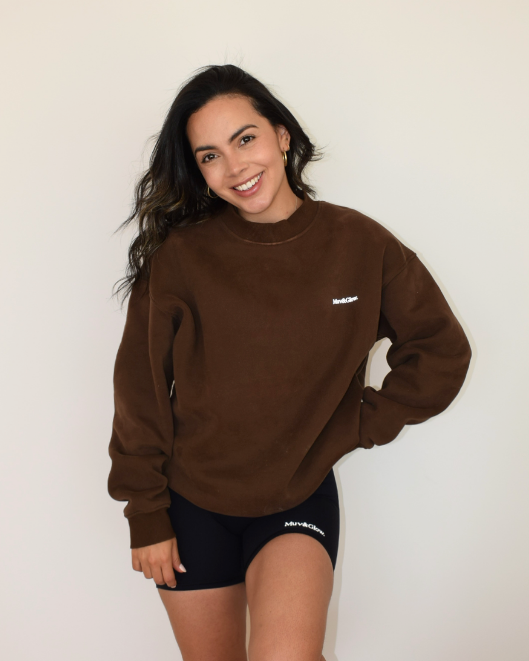 Modelo con el pullover espresso, mano en el cintura, estilo casual
