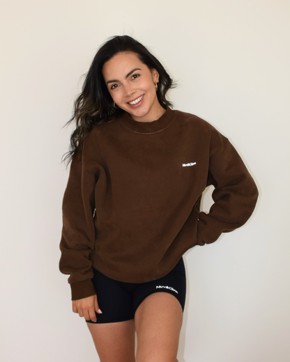 Modelo con el pullover espresso, mano en el cintura, estilo casual
