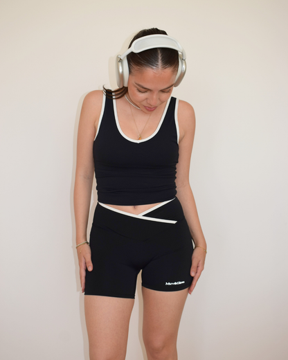 Modelo con gorra usando los Icon Shorts negros con ribete blanco de Muv&Glow
