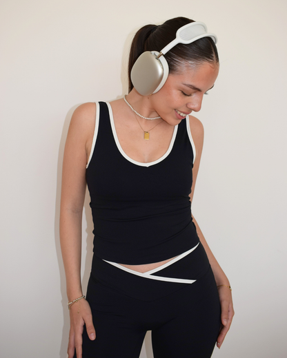 Modelo de frente con manos en la cintura usando el Icon Top negro de Muv&Glow
