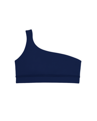 Top Core One-Shoulder azul marino de Muv&Glow en vista flat lay, diseño asimétrico.