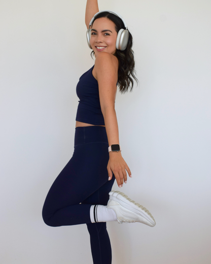 Mujer mostrando el perfil del top The Core Twist Top navy de Muv&Glow.
