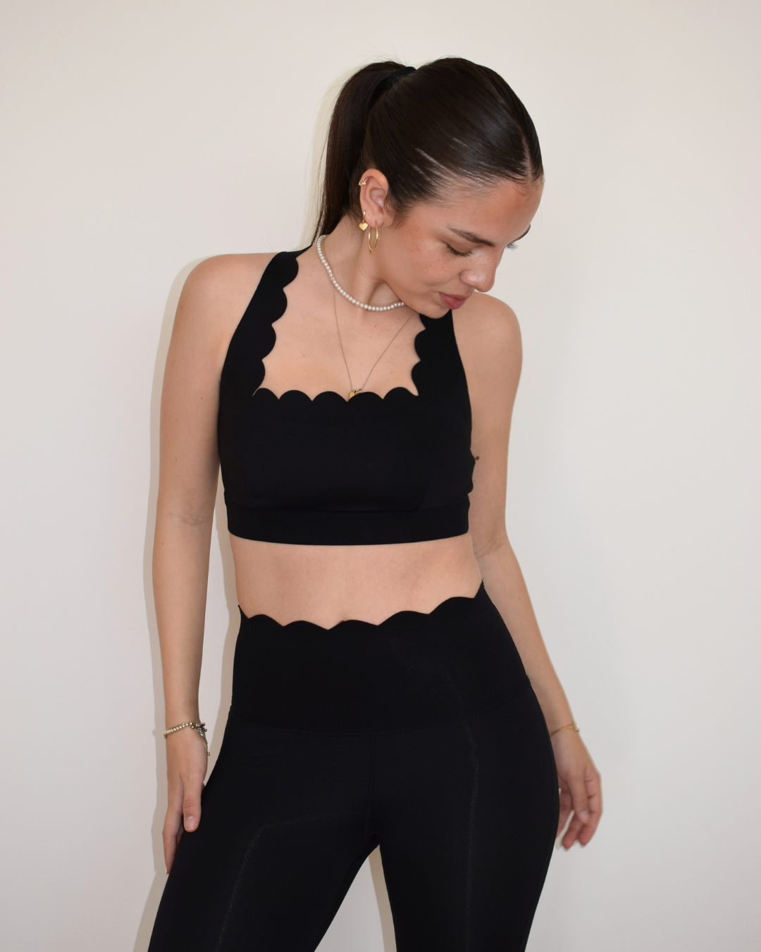 Vista completa frontal del set negro con The Edge Bra y leggings de Muv&Glow.
