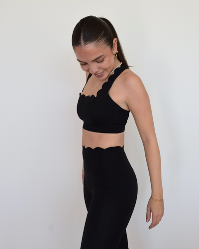 Mujer usando The Edge Bra negro de Muv&Glow en vista lateral.
