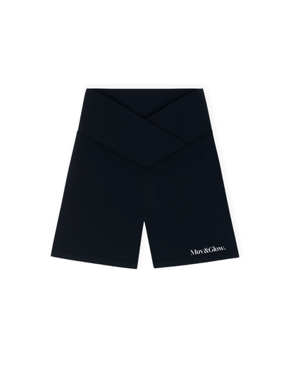 Short deportivo negro cruzado de Muv&Glow, modelo The Icon Shorts, vista flat lay.