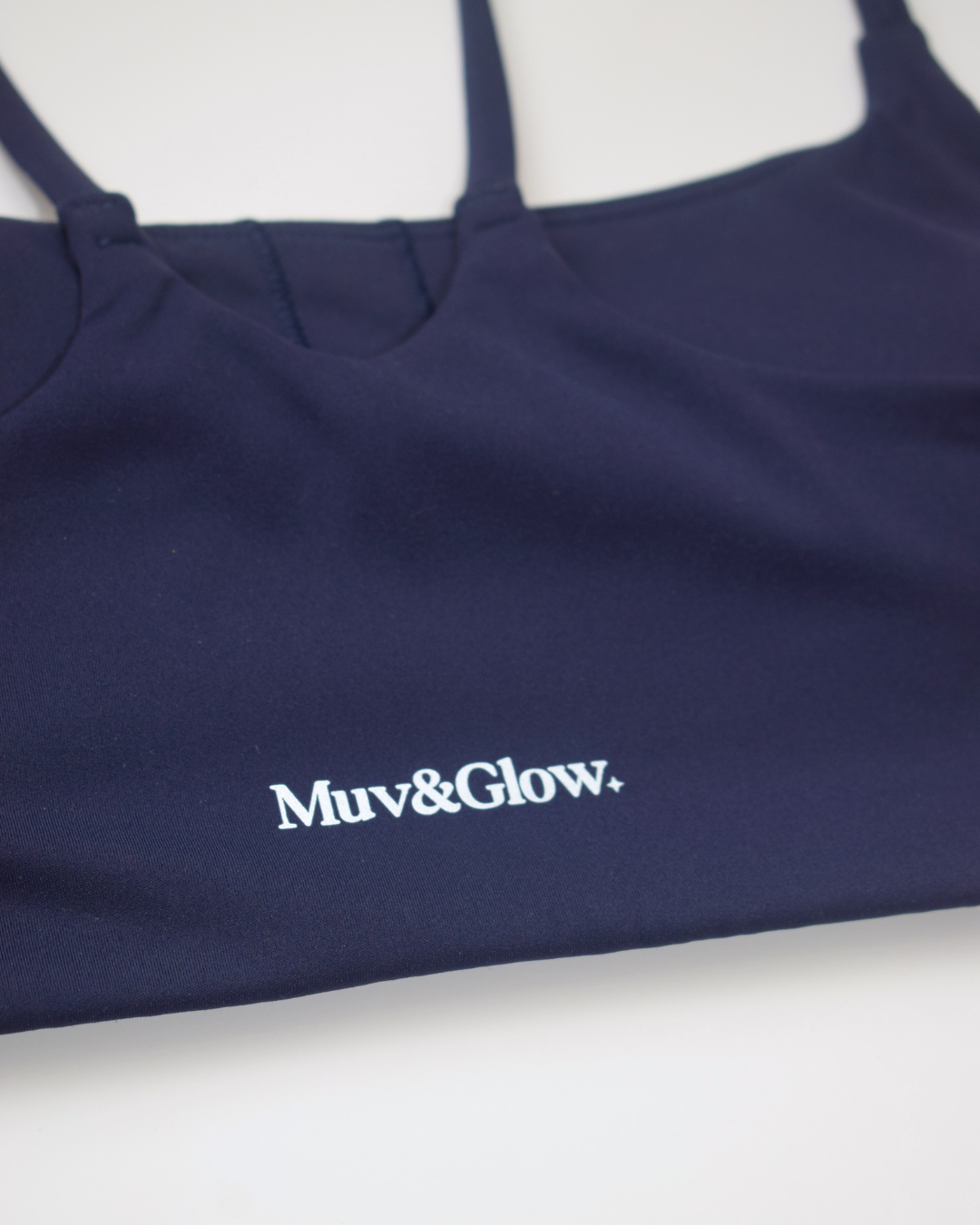 Detalle del logo estampado en el top azul marino de Muv&Glow