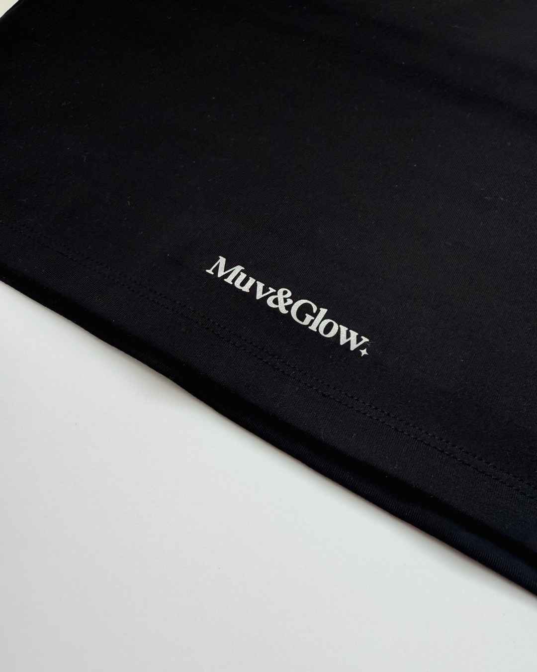 Primer plano del logo estampado sobre el Core Dual Top negro