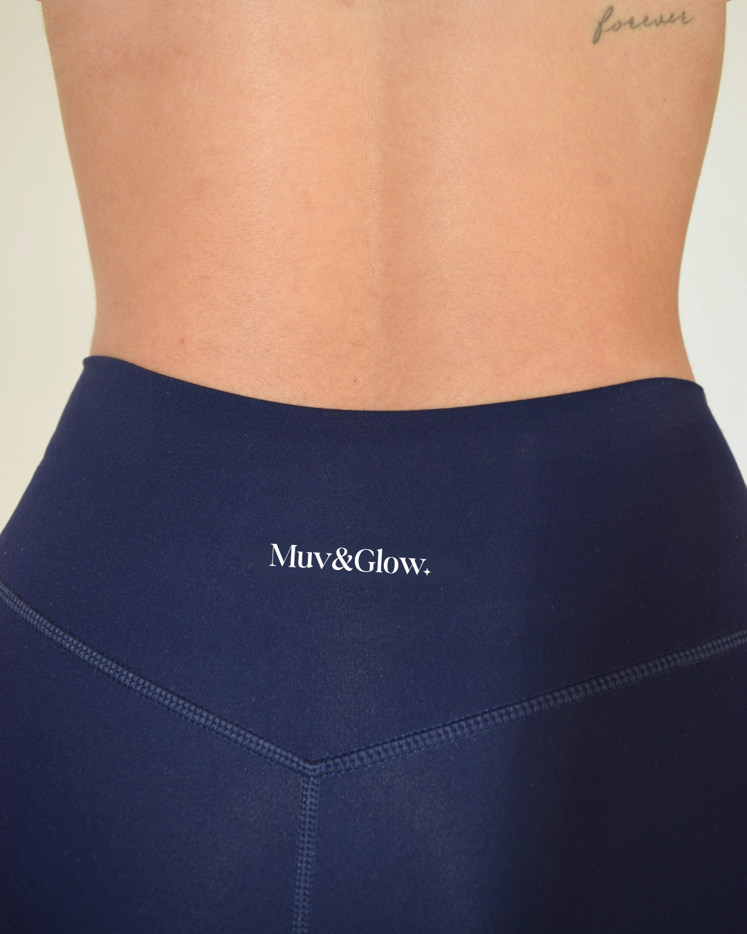 Primer plano de la parte trasera del legging navy con logo Muv&Glow

