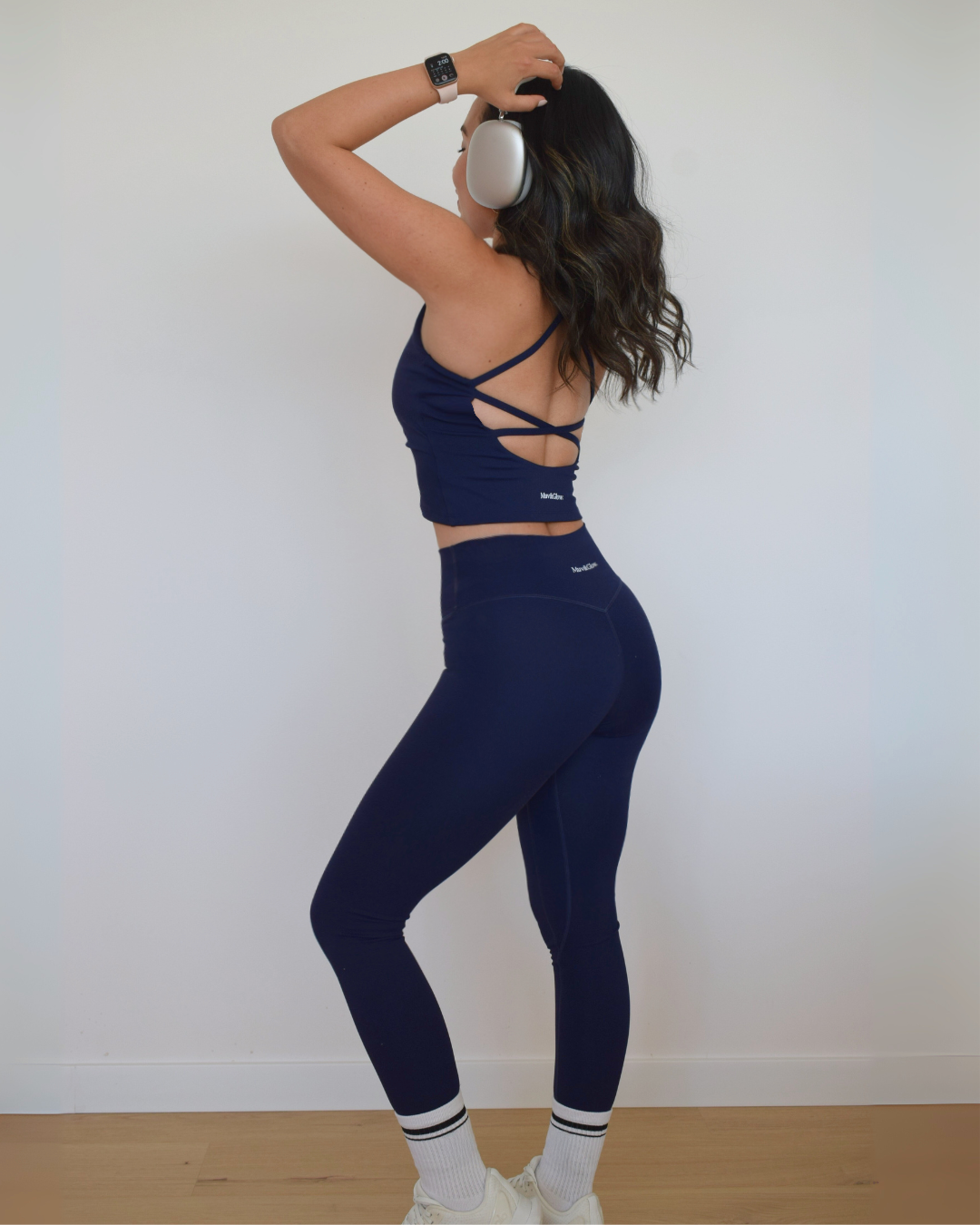 Modelo girada mostrando el costado del legging navy The Core y twist top